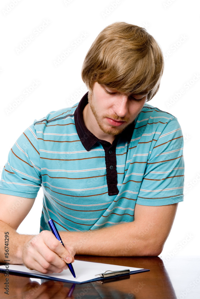 Serious young man sitting at a desk. Serious young man sitting at a desk.