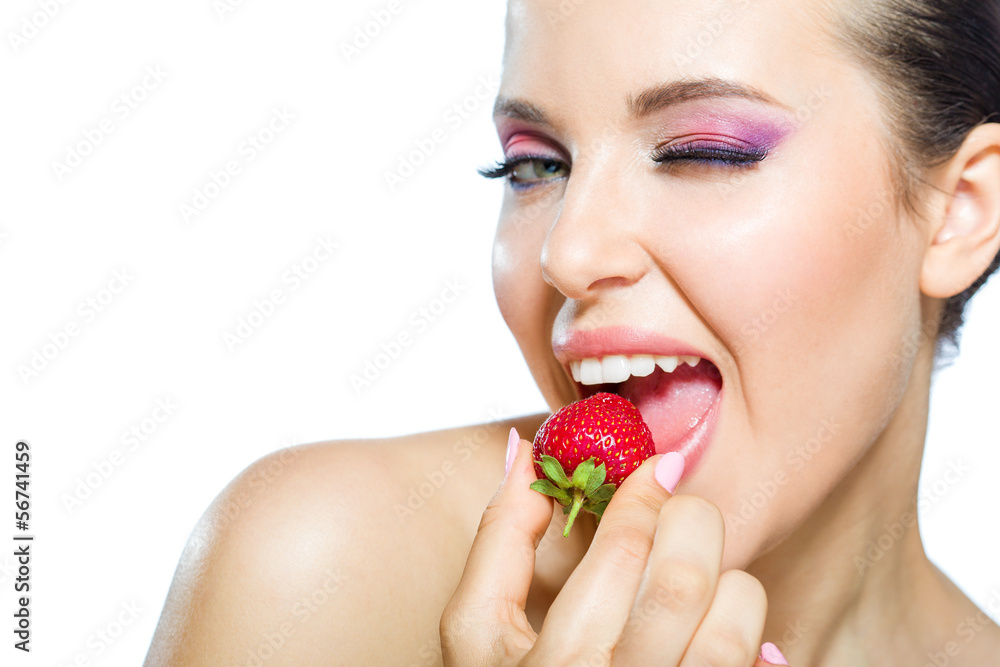 Close up of girl with brilliant pink make-up eating strawberry Close up of girl with brilliant pink make-up eating strawberry