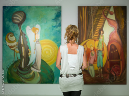 Bild auf Leinwand woman contemplating colorful paintings