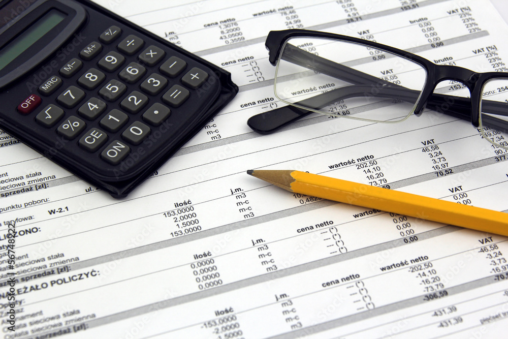 glasses, calculator and pencil on paper bills glasses, calculator and pencil on paper bills