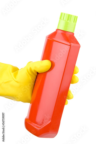 Hand with yellow glove holding bottle of detergent