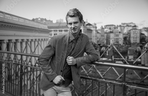 portrait of handsome man standing on rooftop against city view