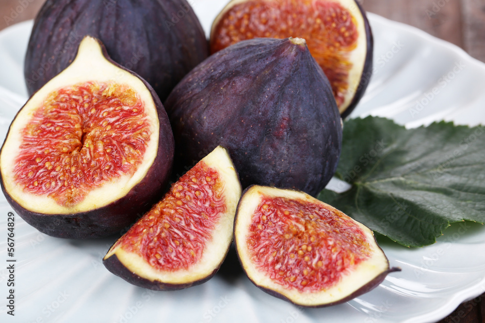 Ripe figs on plate wooden table close-up