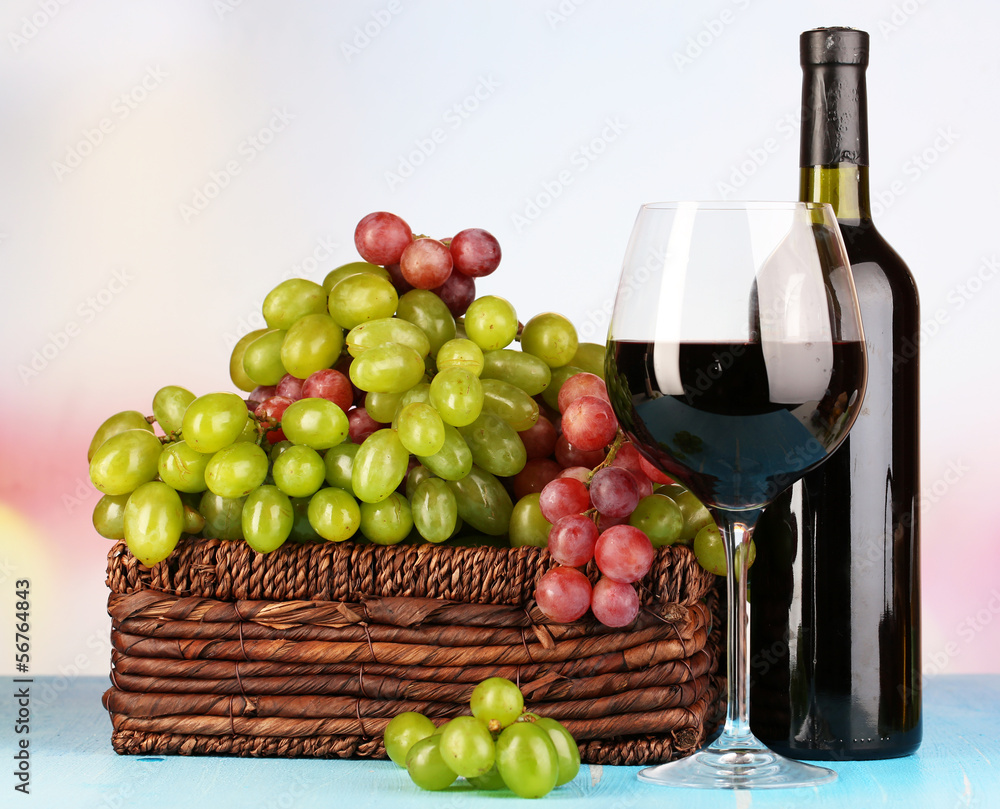 Ripe green and purple grapes in basket with wine