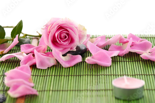 Rose and zen rock with candle on green mat