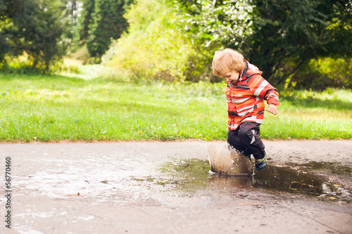Boy running and jumping in puddles
