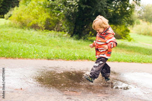 Boy running and jumping in puddles