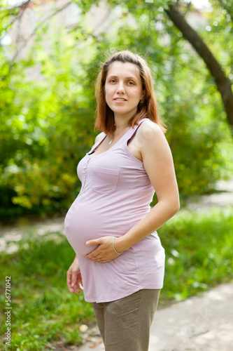  pregnant woman walks in park