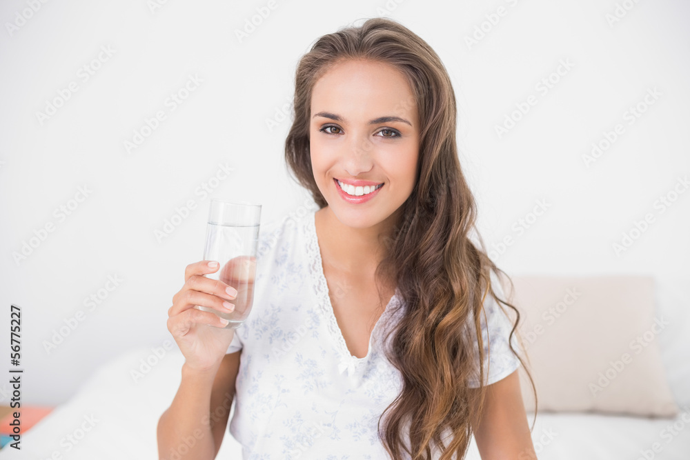 Smiling pretty brunette holding glass of water Smiling pretty brunette holding glass of water