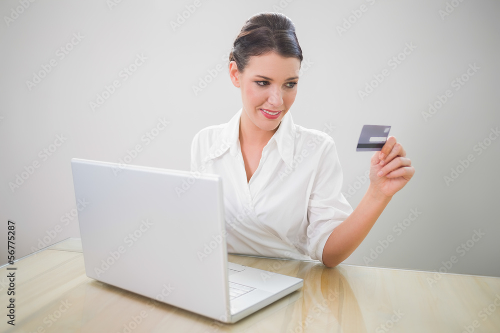 Cheerful pretty businesswoman shopping online using laptop Cheerful pretty businesswoman shopping online using laptop