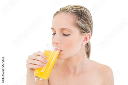 Meditative fresh blonde woman enjoying orange juice