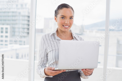 Standing businesswoman using a laptop
