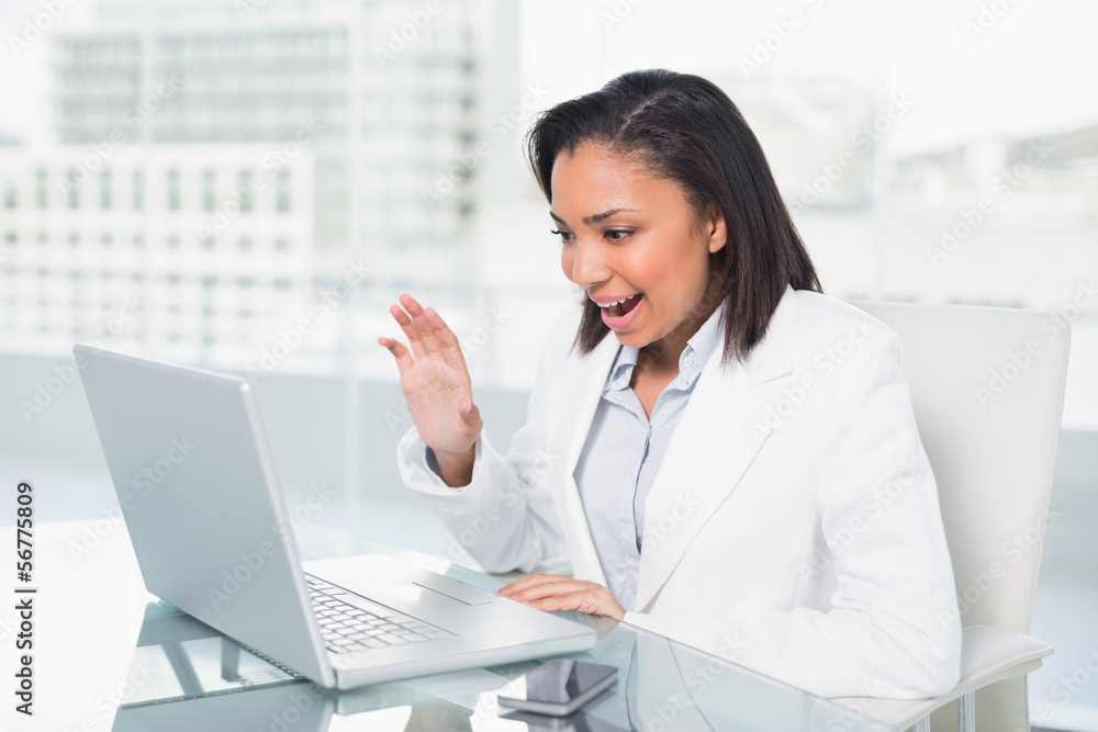 Delighted young dark haired businesswoman chatting on her laptop Delighted young dark haired businesswoman chatting on her laptop