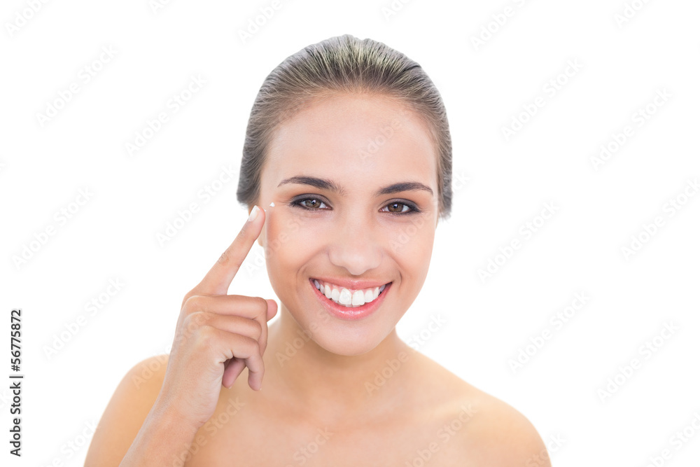 Smiling brunette woman pointing at her eye Smiling brunette woman pointing at her eye
