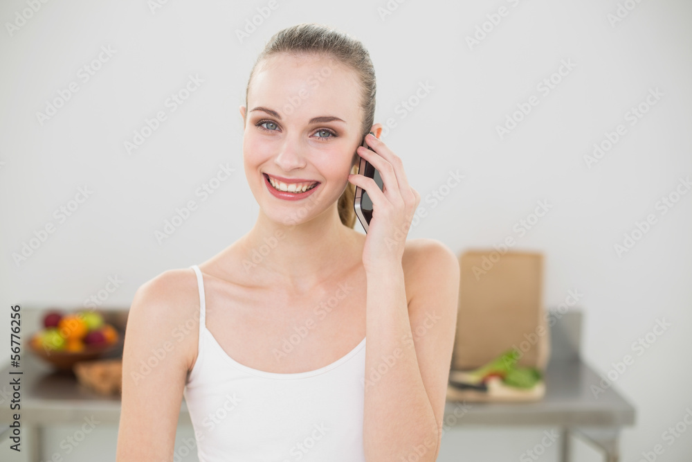 Happy young woman talking on smartphone smiling at camera Happy young woman talking on smartphone smiling at camera