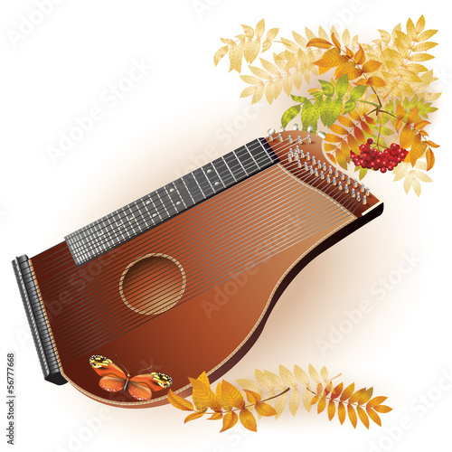 Traditional zither on white autumn background with yellow leaves photo