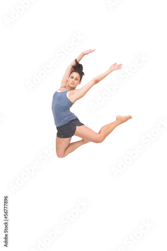 Pretty sporty brunette jumping in the air with arms up