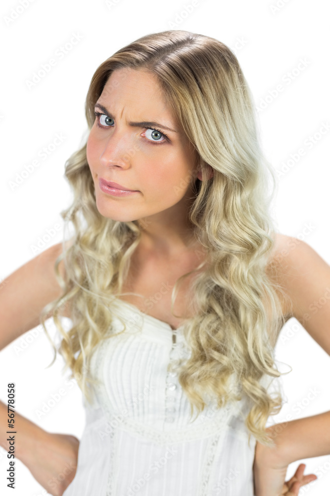 Angry blond model in white dress frowning at camera Angry blond model in white dress frowning at camera