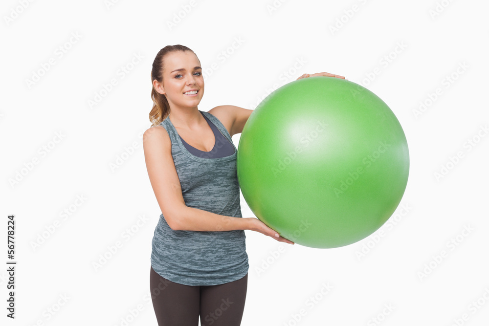 Lovely young woman presenting a fitness ball Lovely young woman presenting a fitness ball