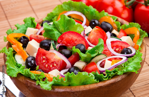 Delicious and healthy salad in a wooden bowl