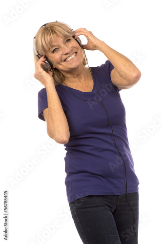 Femme senior 50-60ans écoutant de la musique avec un casque aud
