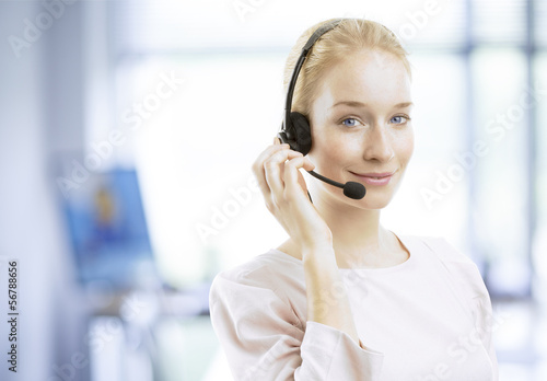 Smiling young female customer service agent with headset © sepy