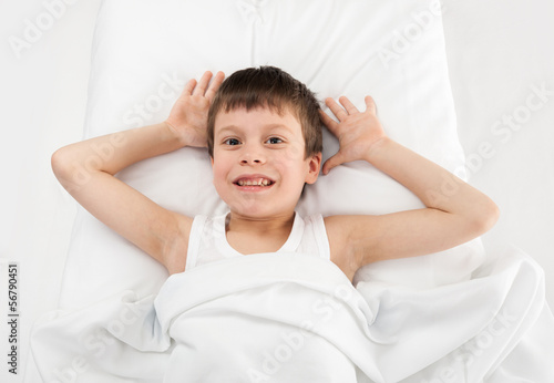 cheerful boy in white bed