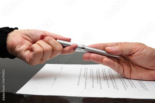 businessman giving pen to businesswoman for signing contract or
