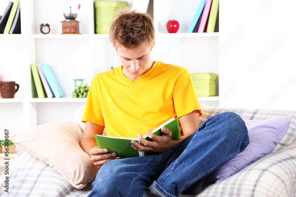 Young man relaxing on sofa with book Young man relaxing on sofa with book