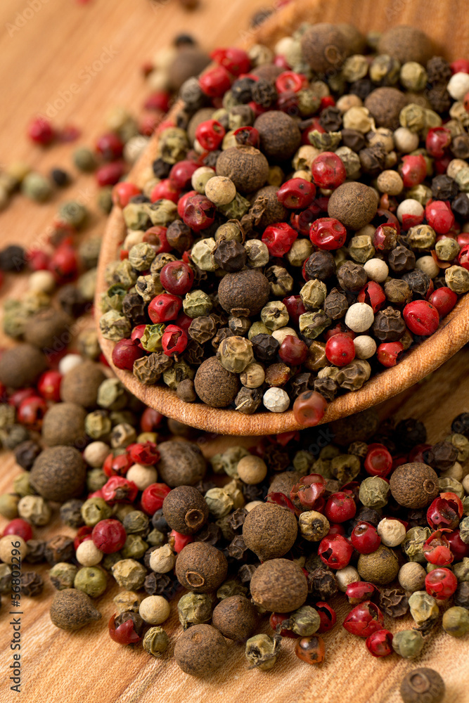 Peppercorn mix in a wooden spoon Peppercorn mix in a wooden spoon