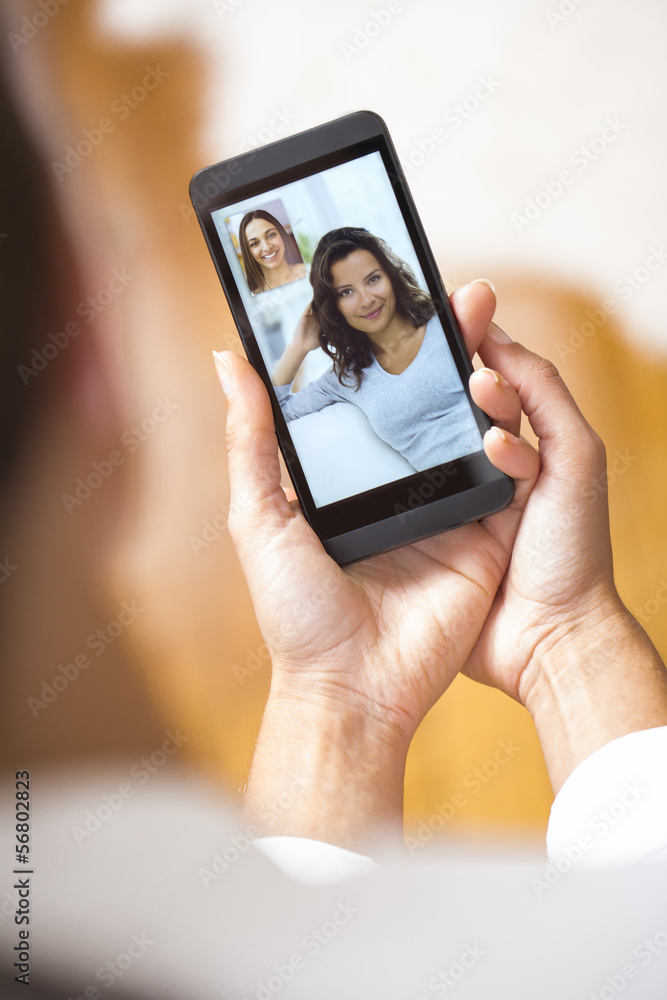 Closeup of a female hand holding a smartphone during a skype vid