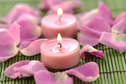 Rose petals with candle on bamboo green mat