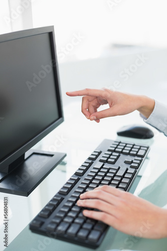Close up of a businesswoman pointing to her computer screen with