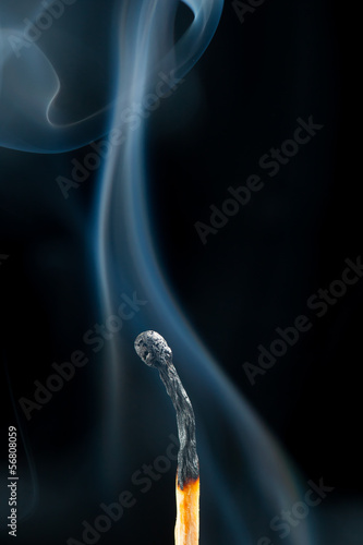 burnt match with smoke, black background