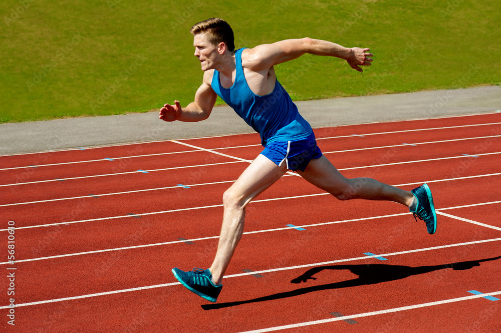 Obraz premium Young caucasian athlete sprinting on track