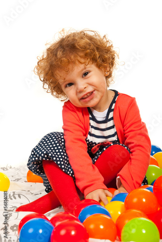 Happy toddler girl with colorful balls