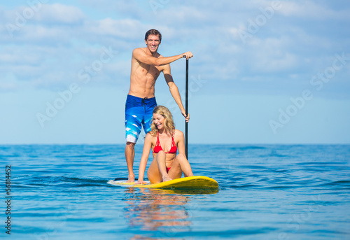 Couple Stand Up Paddle Surfing In Hawaii