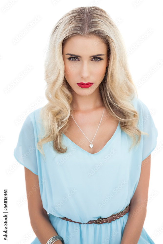Puzzled blonde model in blue dress looking at camera Puzzled blonde model in blue dress looking at camera