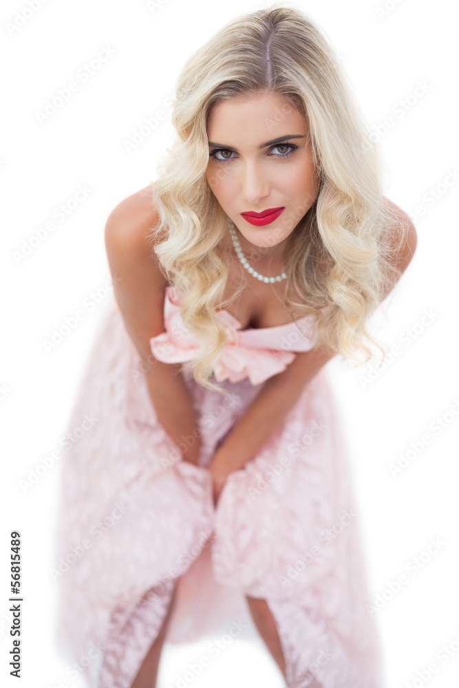 Pretty blonde model in pink dress posing hands on the thighs Pretty blonde model in pink dress posing hands on the thighs