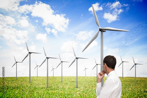 Thoughtful classy businessman looking at windmill