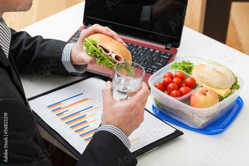 Manager eating a sandwich during work photo