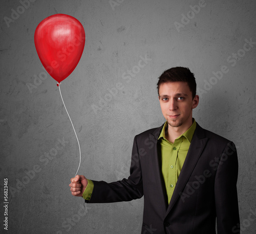Businessman holding a red balloon