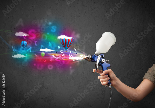 Worker with airbrush and colorful abstract clouds and balloons