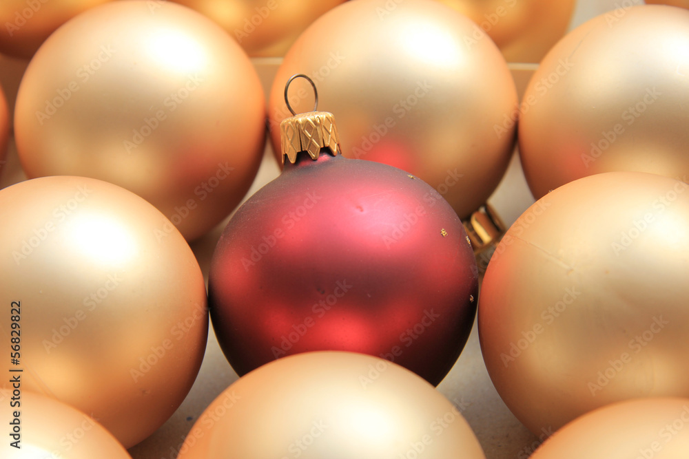 Red ornament on a pile of golden ornaments Red ornament on a pile of golden ornaments