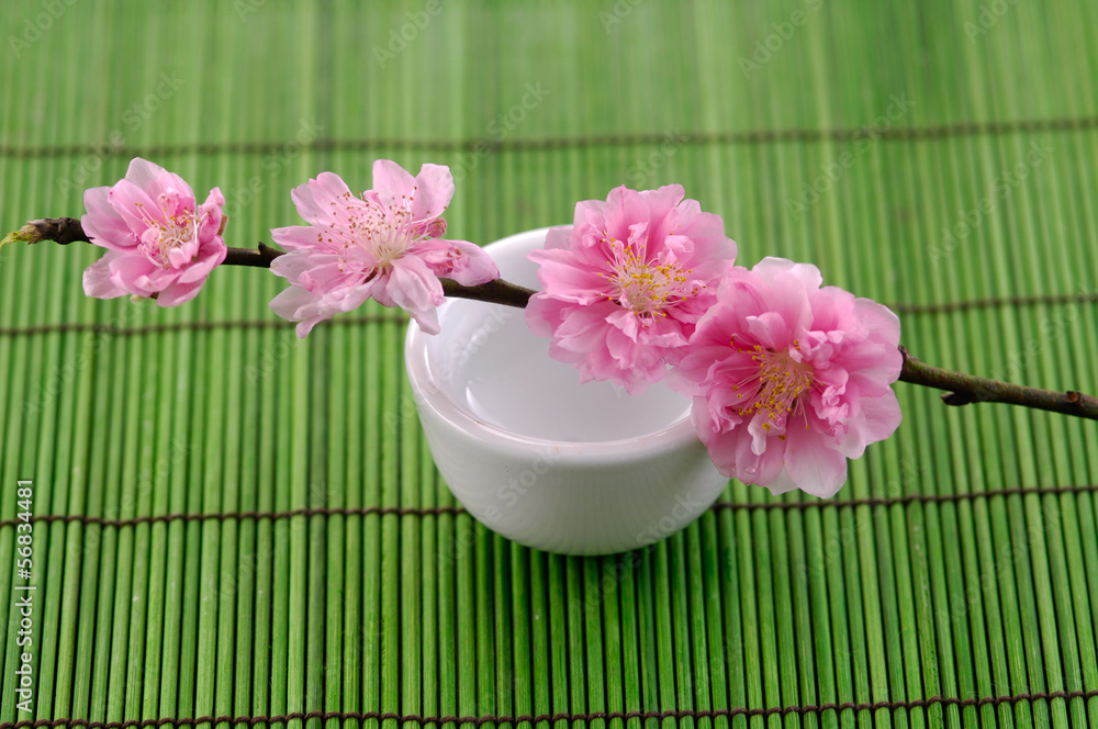 Spring branch Cherry blossoms in vase on mat Spring branch Cherry blossoms in vase on mat