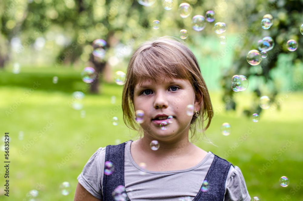 Little girl playing with soap bubbles in summer park Little girl playing with soap bubbles in summer park