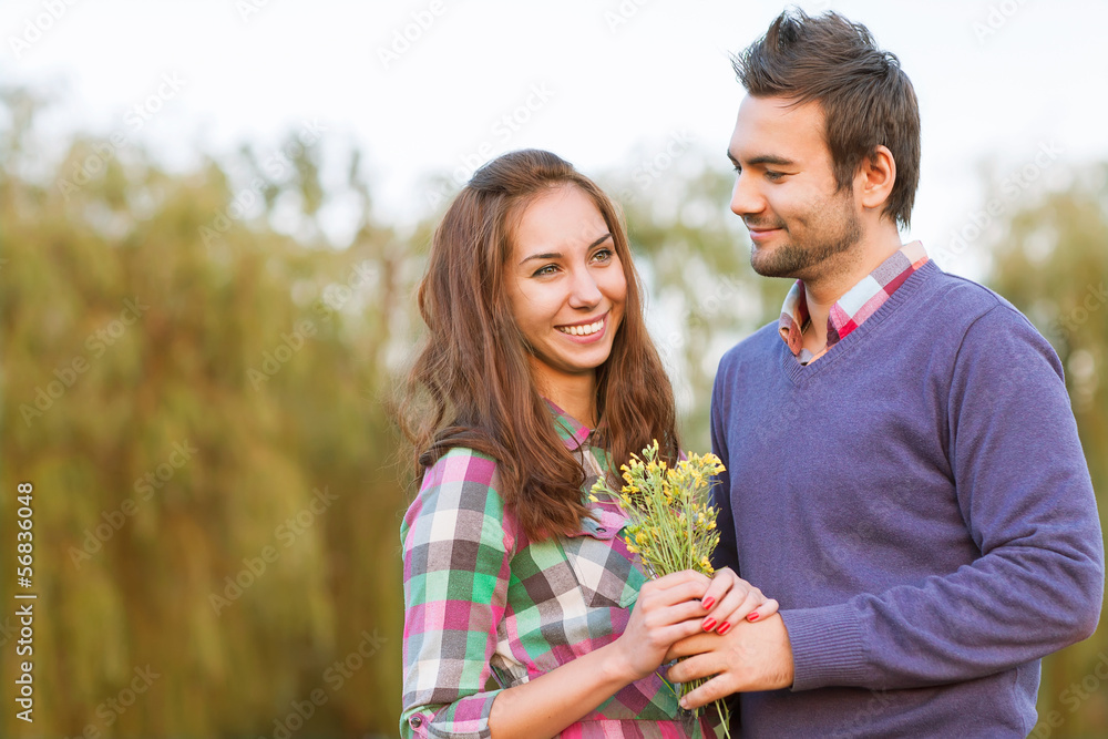 Young couple in love walking in the autumn park near the river. Young couple in love walking in the autumn park near the river.
