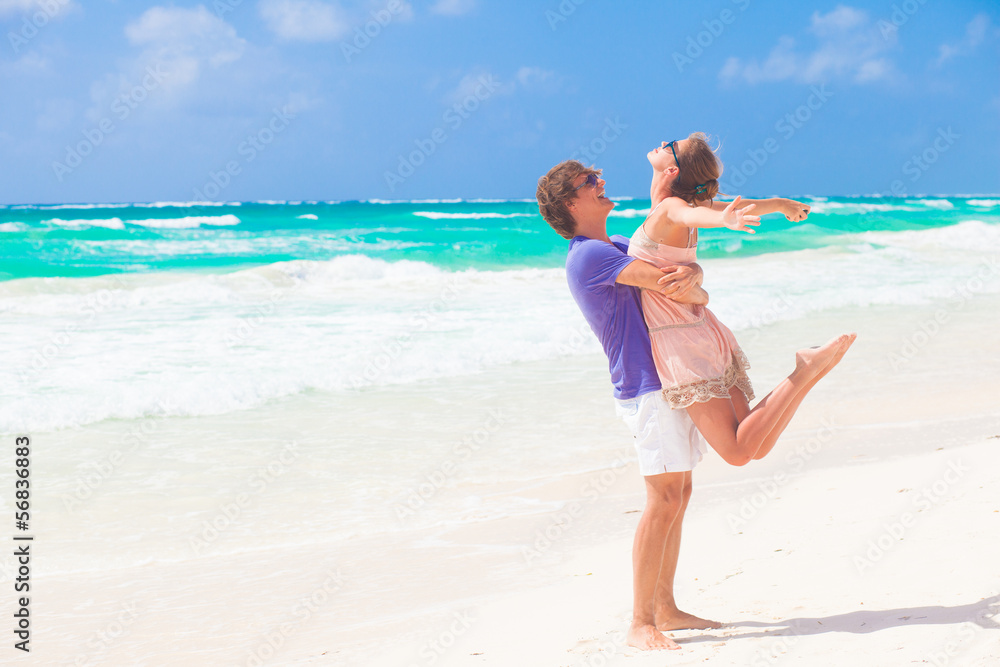 Couple walking and having fun on a tropical beach at Maldives