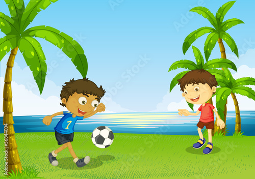 Boys playing football at the riverbank