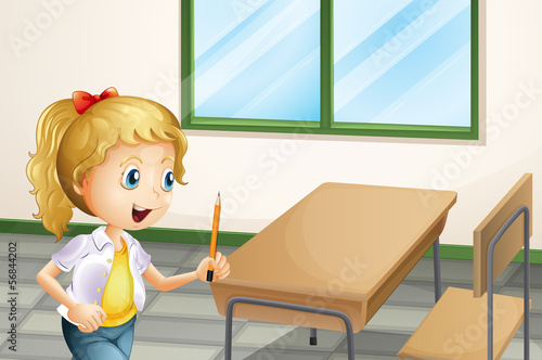 A girl holding a pencil inside the classroom
